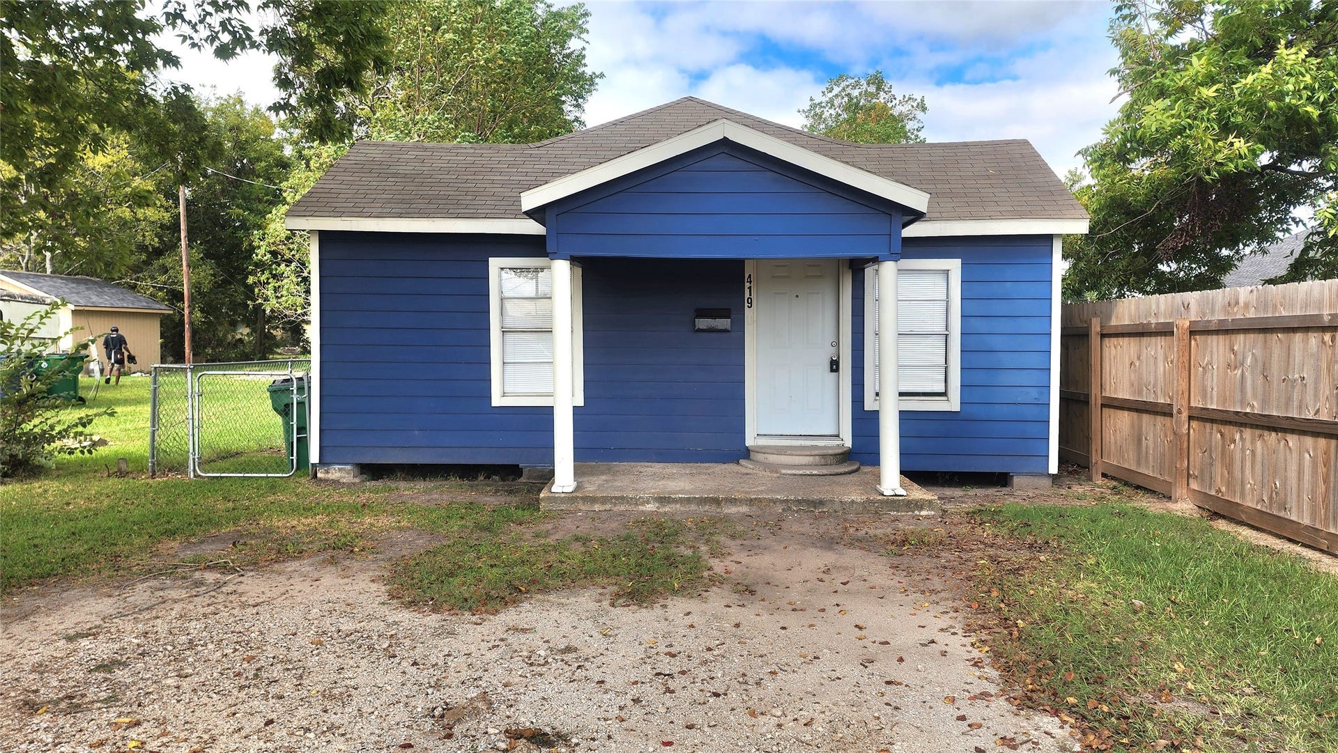 419 N Parrish Street, Angleton, TX 77515 Front of the home: blue exterior with white trim and privacy fencing.