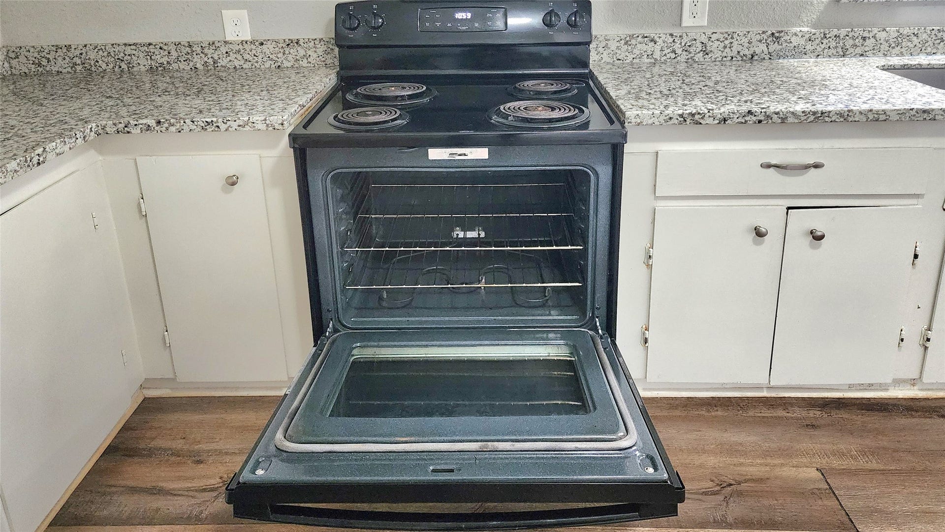 419 N Parrish Street, Angleton, TX 77515 Electric range and oven set between white cabinetry.