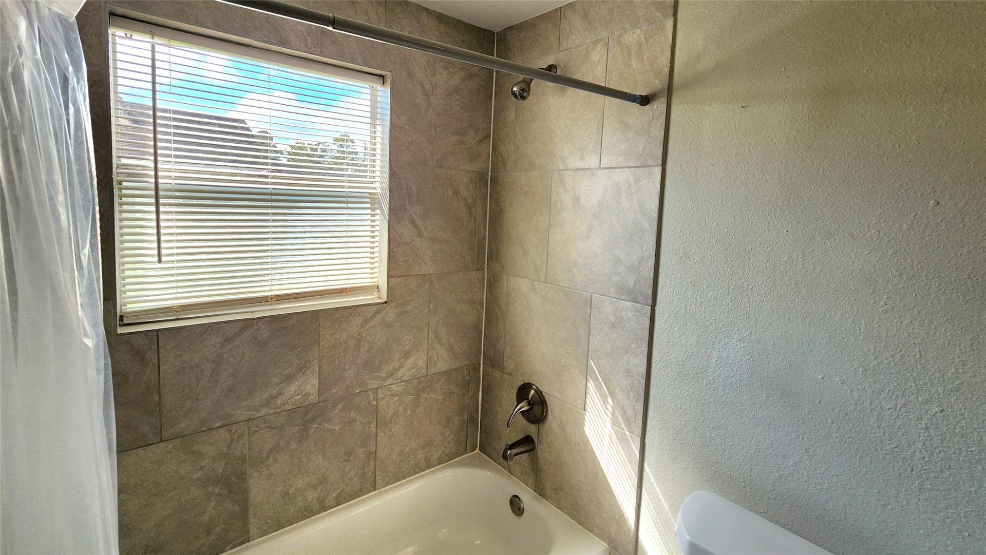 419 N Parrish Street, Angleton, TX 77515 Closer look at tiled tub and shower in the hallway bath.
