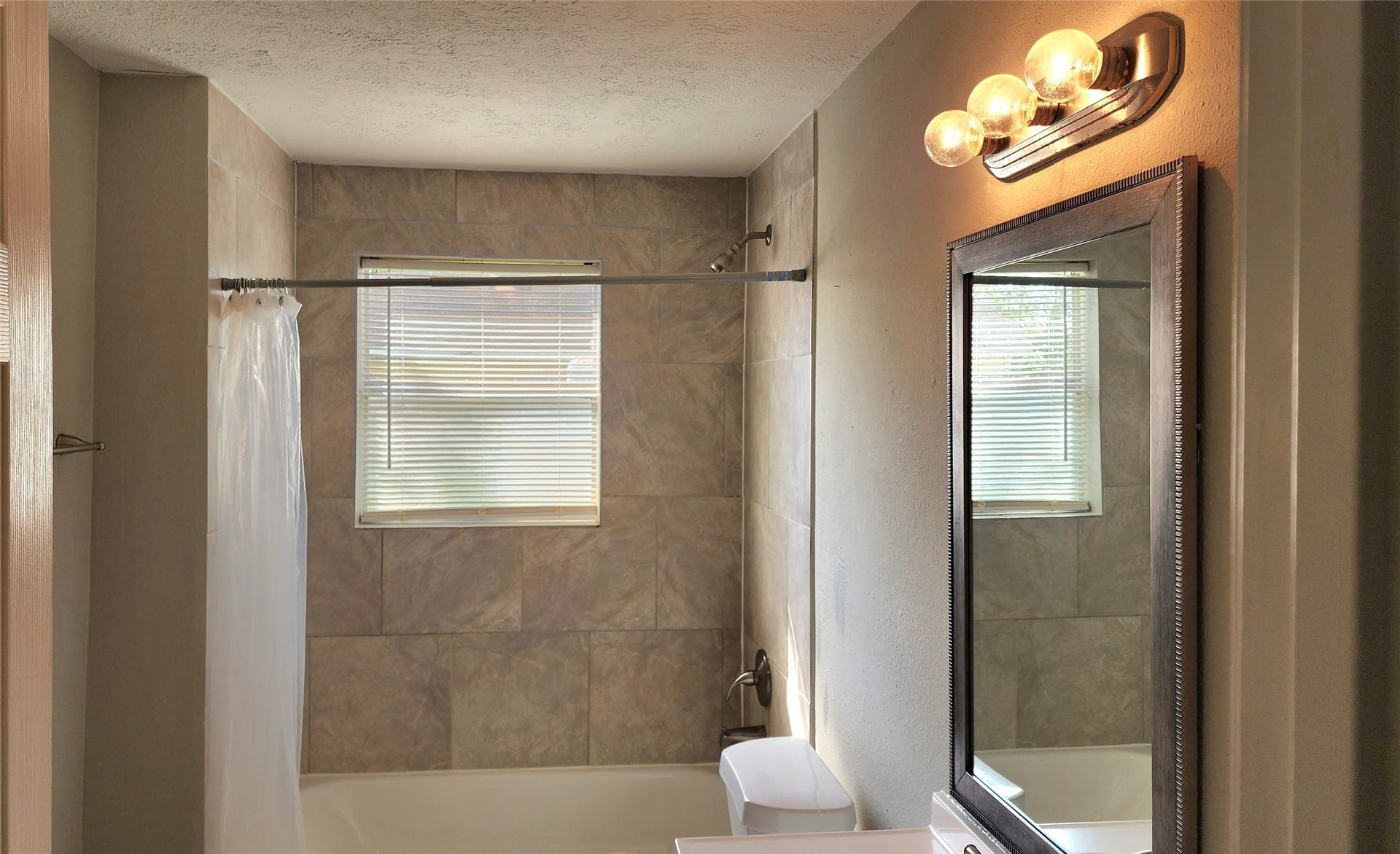 419 N Parrish Street, Angleton, TX 77515 Hallway bath with tile surround to the ceiling, and a window for natural light.