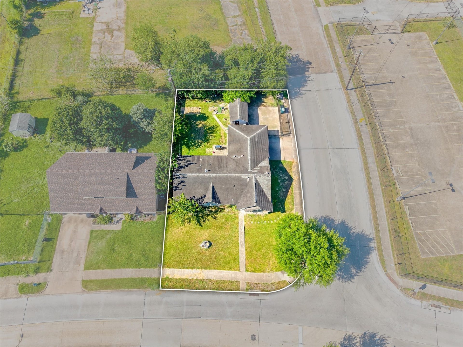 This aerial view of the corner lot showcases the front of the home, highlighting its curb appeal and surrounding property.