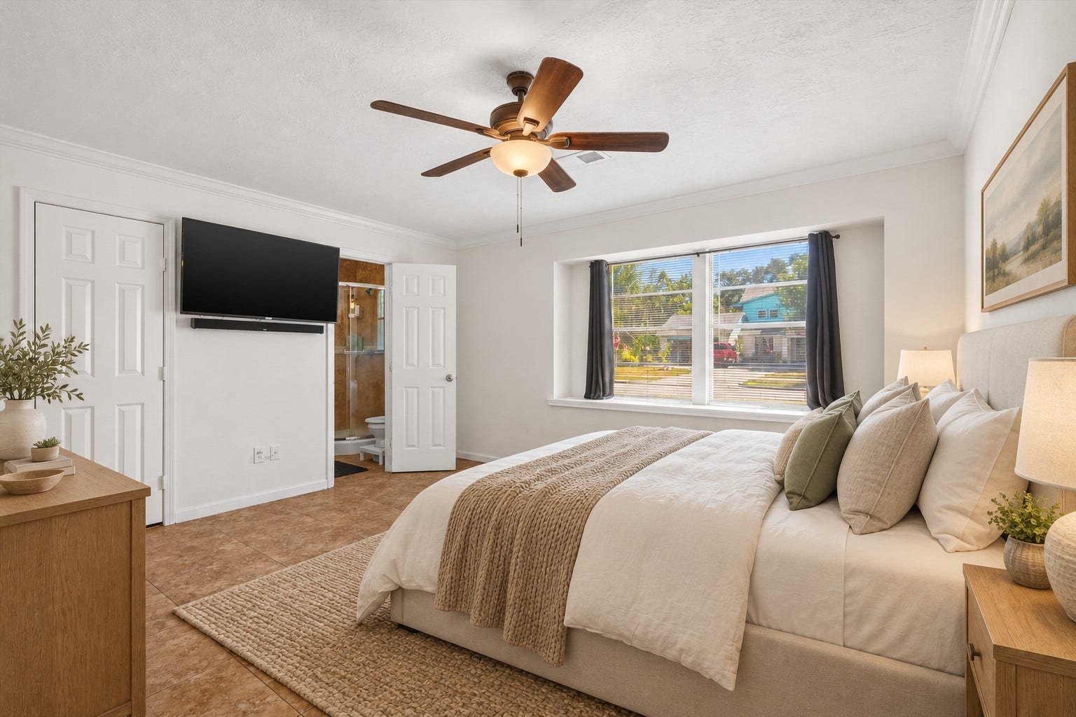 Relax in the spacious primary bedroom, featuring beautiful tile flooring, a large window with privacy blinds, and a ceiling fan  creating a bright, comfortable, and elegant space designed for rest and relaxation. *Virtually Staged
