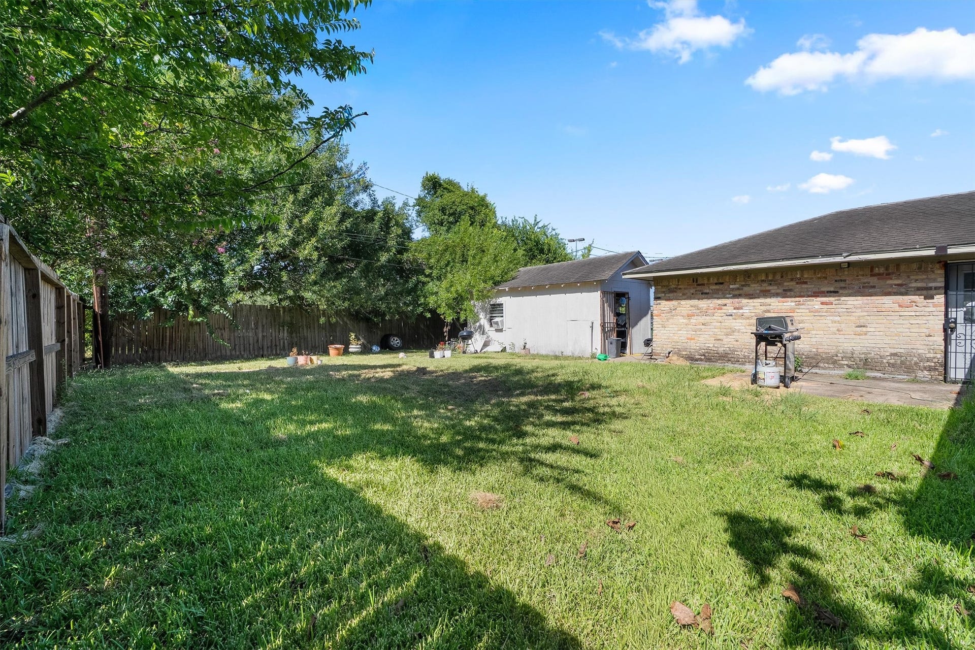 Enjoy this fenced-in backyard with a well-maintained lawn and a cozy patio, perfect for outdoor gatherings, relaxing in the sun, or creating your own garden oasis.
