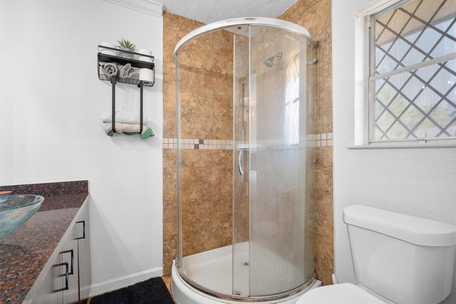 Another view of the primary bathroom highlights the spacious walk-in shower, along with a conveniently positioned toilet for added functionality and comfort.
