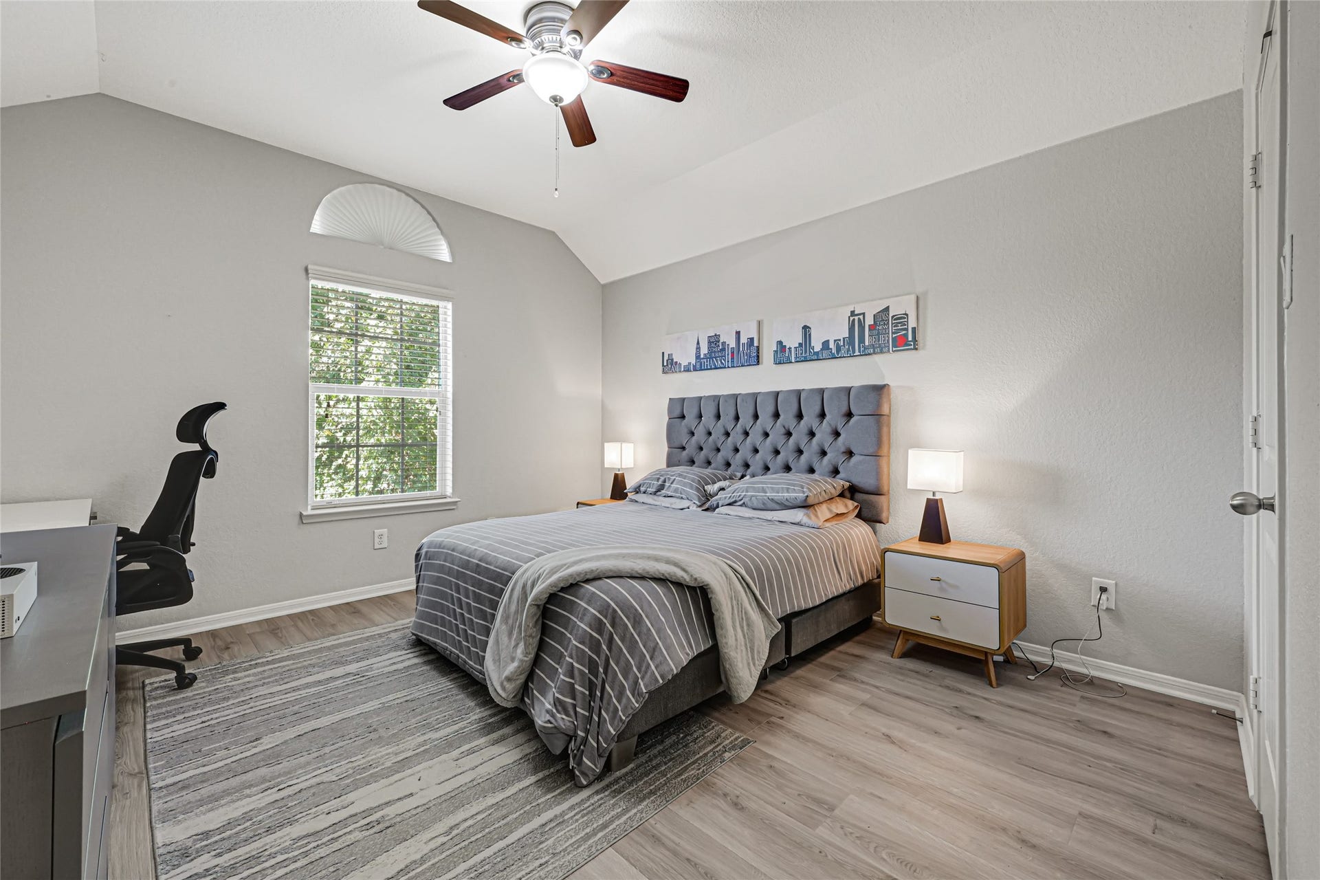 One of three secondary bedrooms upstairs. Spacious bedroom with a vaulted ceiling and walk in closet