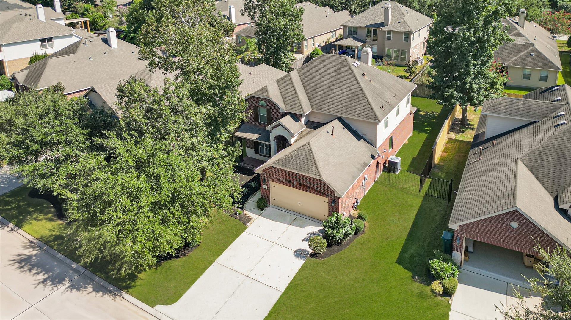 Charming two-story brick home nestled in a lush suburban neighborhood, featuring a spacious driveway and well-maintained front yard.