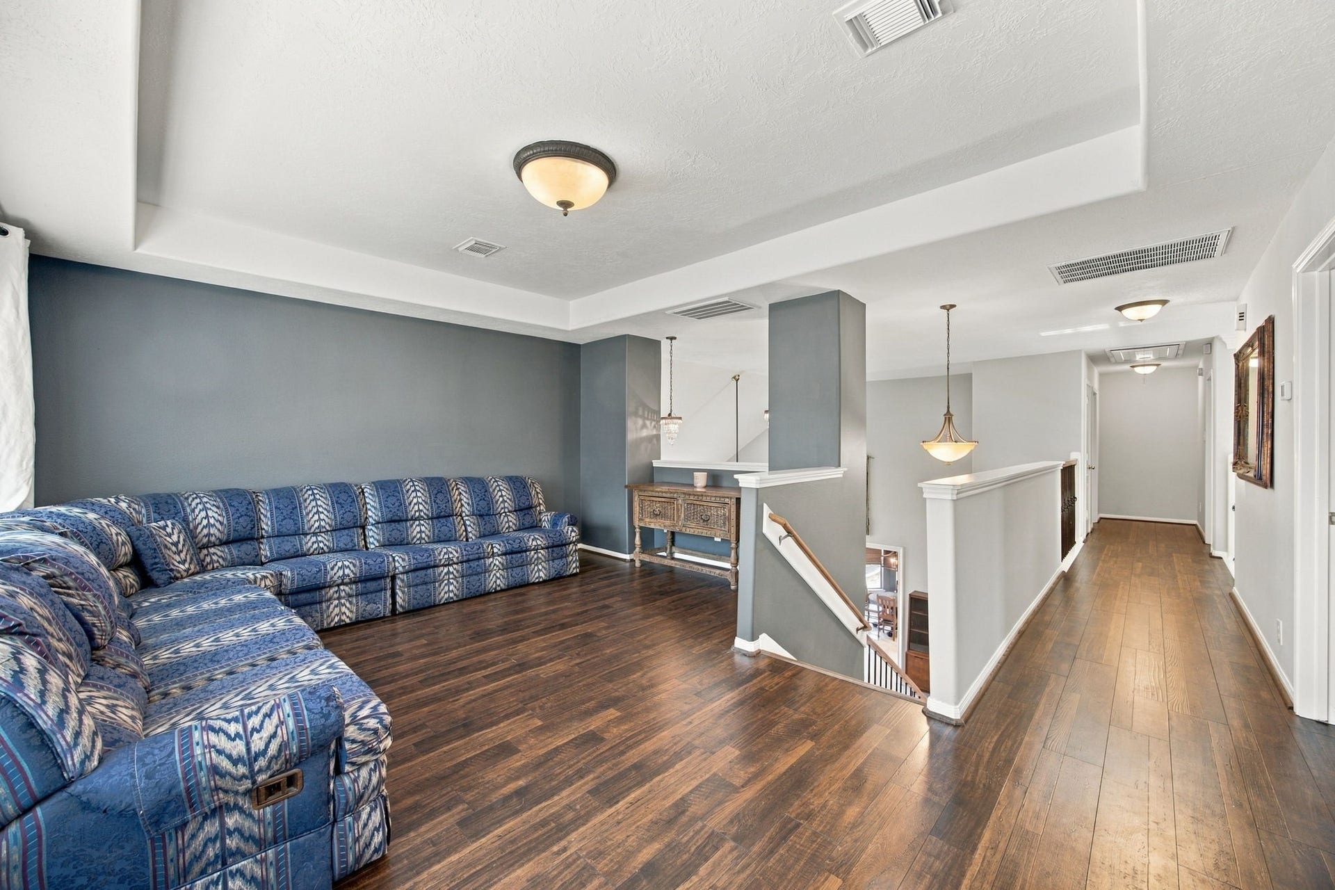 2417 La Rochelle Court, Seabrook, TX 77586 Spacious upstairs living area with rich hardwood floors, stylish lighting, ideal for relaxation or entertaining.
