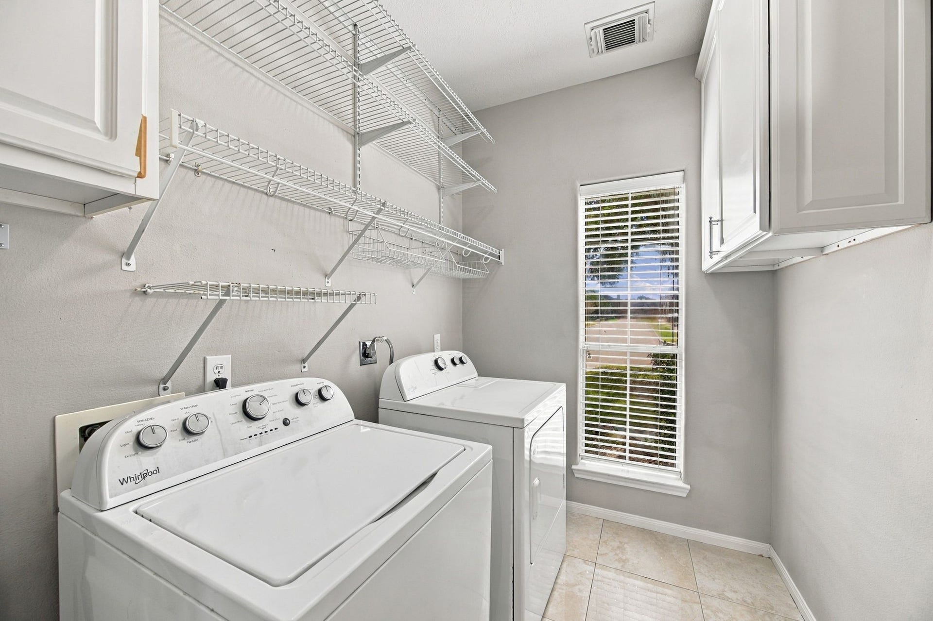 2417 La Rochelle Court, Seabrook, TX 77586 Bright and functional laundry room, ample shelving, and a window for natural light.