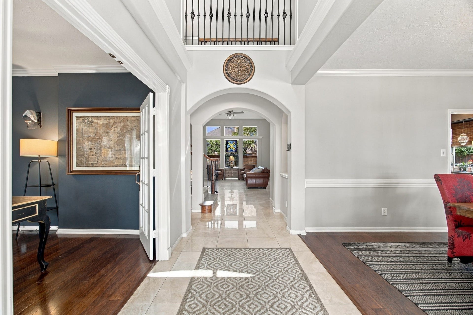 2417 La Rochelle Court, Seabrook, TX 77586 Elegant foyer with high ceilings and an arched entryway leads to a spacious living area, featuring rich wood and tile flooring, and abundant natural light.