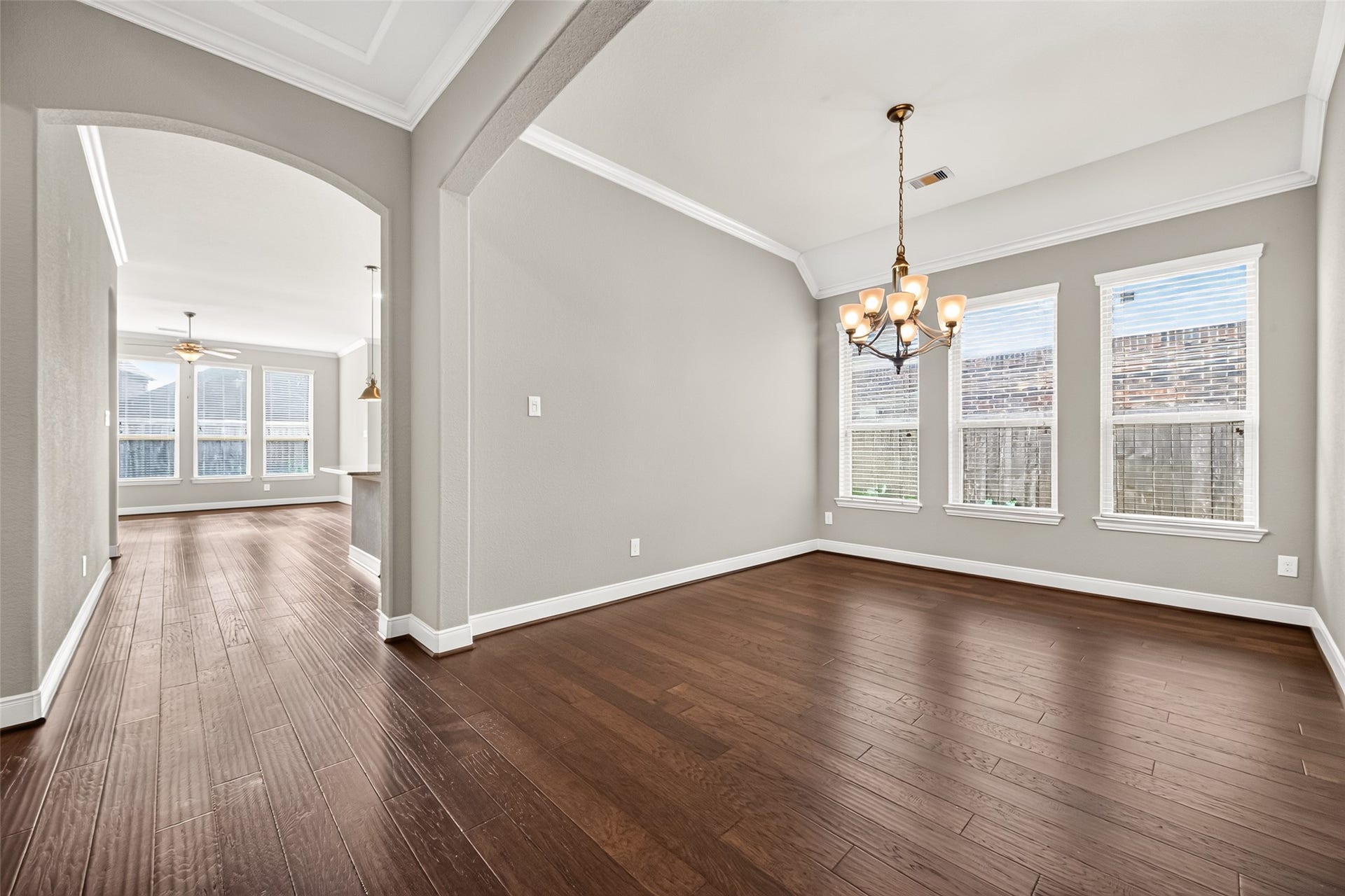 A formal dining room framed by an elegant curved archway provides a beautiful setting for gatherings and entertaining.