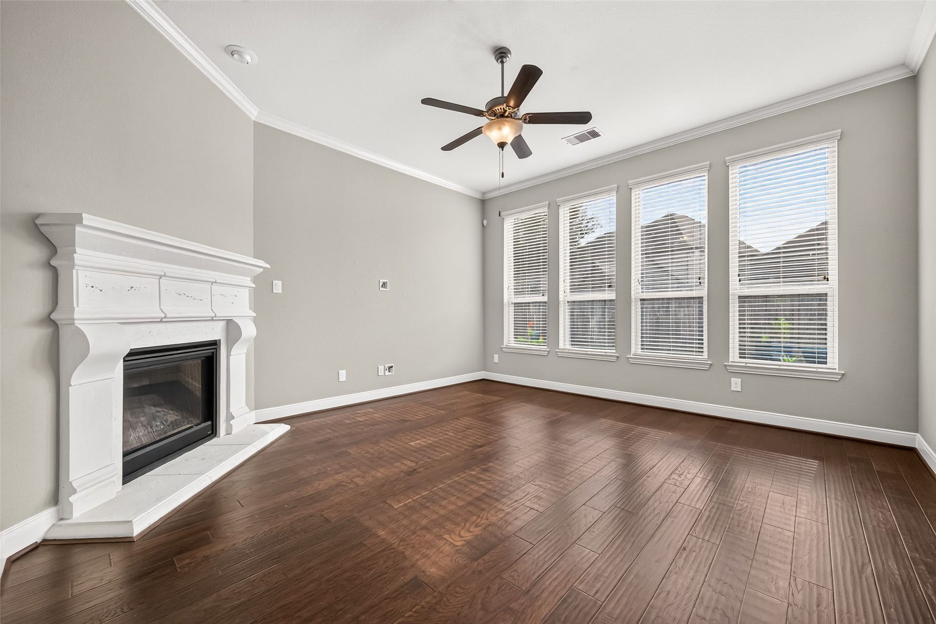 The spacious family room features a cozy fireplace and wall of windows overlooking the backyard, filling the space with natural light.