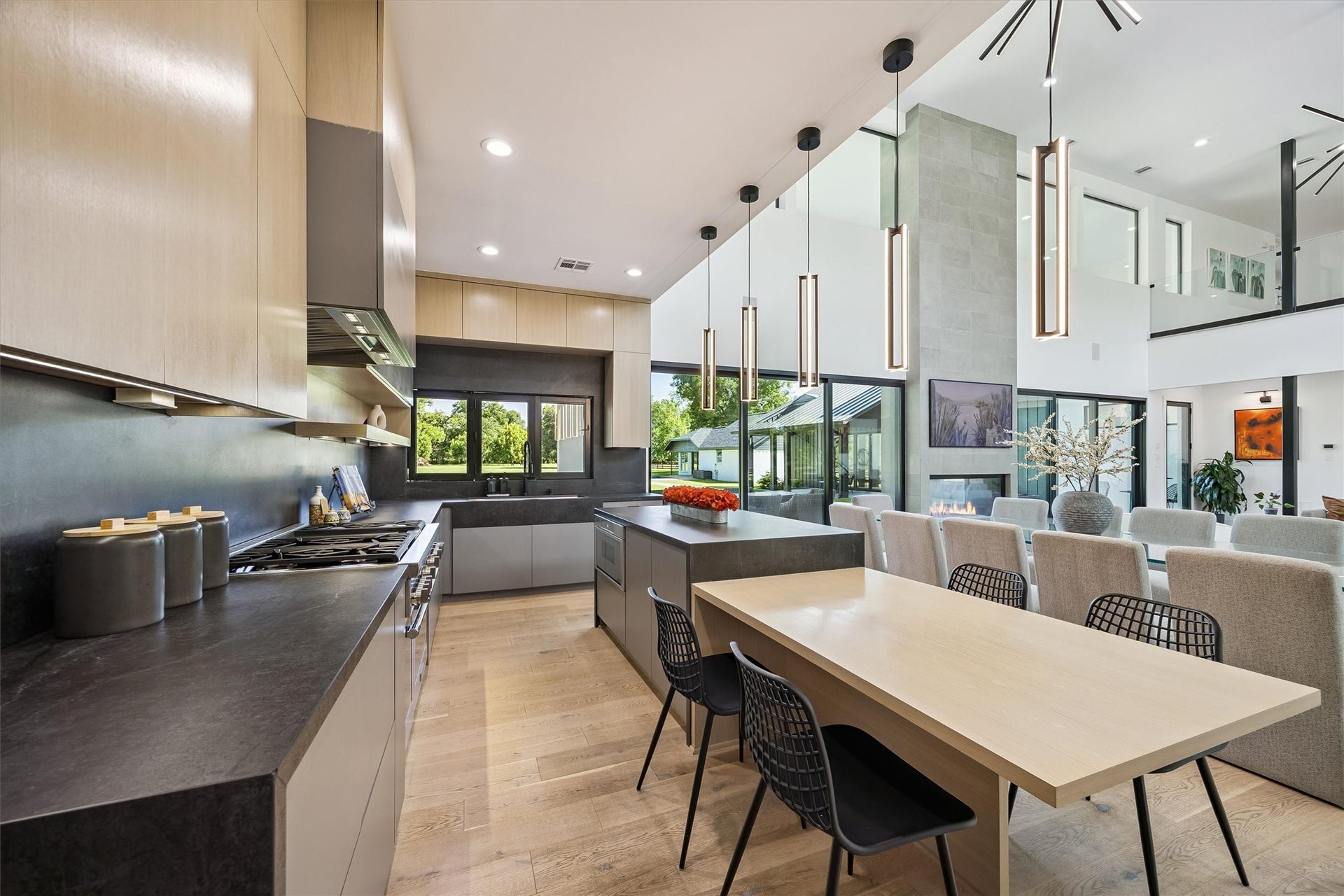 5210 Manor Drive, Sugar Land, TX 77479 Sleek modern kitchen with high-end appliances, a large island, and open layout leading to a spacious living area. Natural light floods the space, highlighting the elegant design and contemporary lighting fixtures.