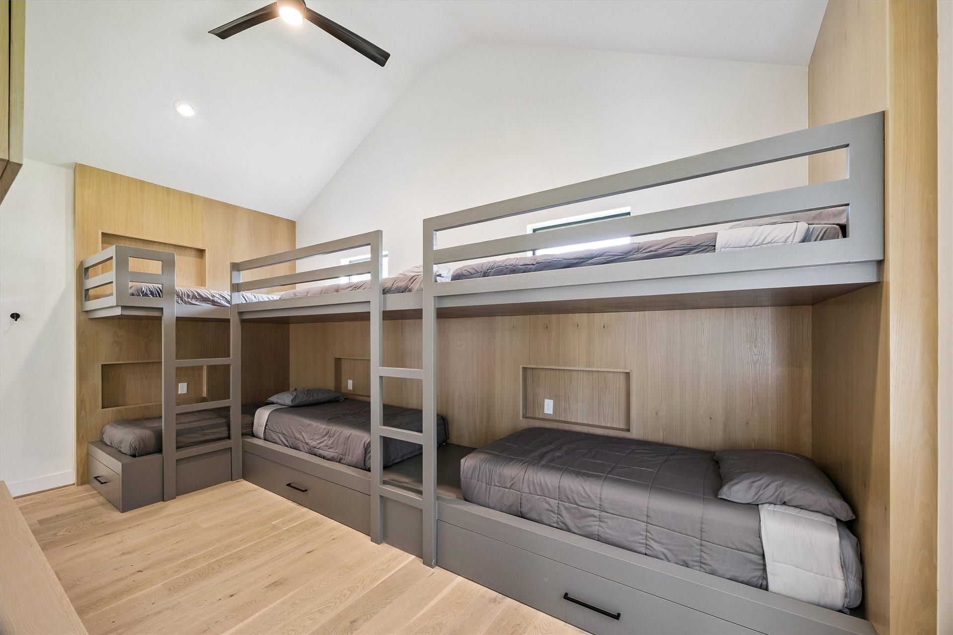 5210 Manor Drive, Sugar Land, TX 77479 Modern bunk room with sleek gray frames, cozy bedding, and ample storage, perfect for maximizing space and comfort.