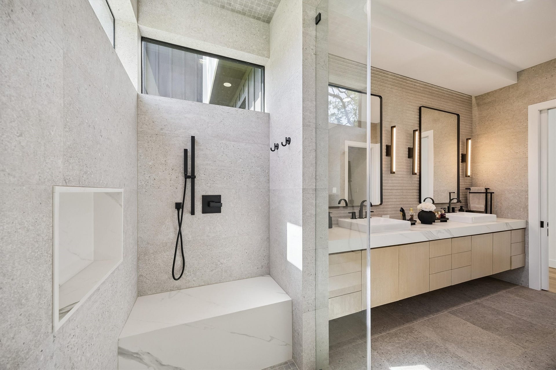 5210 Manor Drive, Sugar Land, TX 77479 Elegant bathroom featuring a spacious walk-in shower with sleek black fixtures and a modern double vanity, complemented by ample natural light and contemporary finishes.