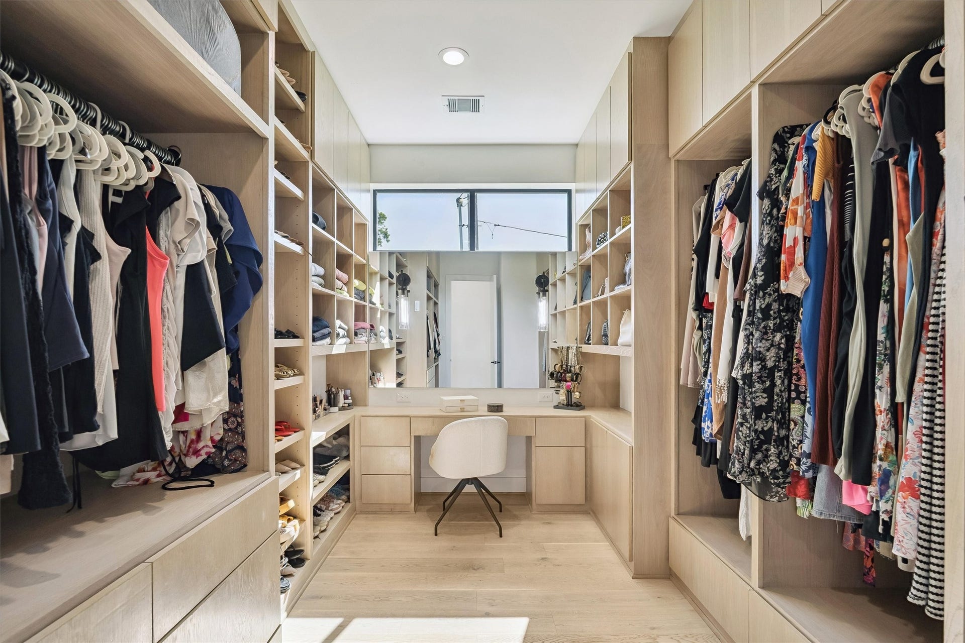 5210 Manor Drive, Sugar Land, TX 77479 Spacious walk-in closet with ample shelving, hanging space, and a chic vanity area, perfect for organizing and dressing in style.