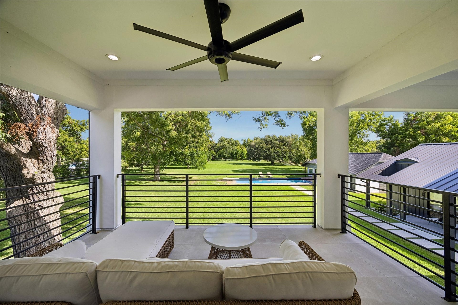 5210 Manor Drive, Sugar Land, TX 77479 Spacious covered patio with comfortable seating, overlooking a lush, expansive lawn and sparkling pool, perfect for relaxation and outdoor enjoyment.