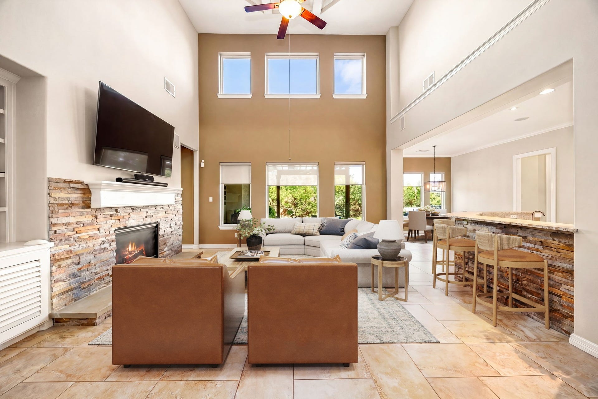 5102 Hawthorne Bend Drive, Katy, TX 77494 This stunning living room boasts soaring two-story ceilings, a gorgeous stacked stone fireplace, and an open flow into the wet bar and dining area, perfect for entertaining. *Virtually Staged