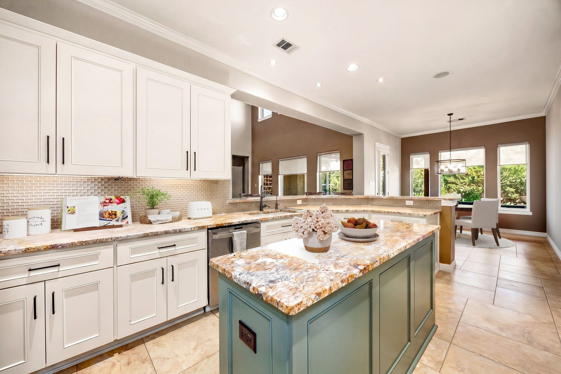 5102 Hawthorne Bend Drive, Katy, TX 77494 A chef's dream! This stunning kitchen features white cabinetry with black hardware, an eye-catching sage green island, gorgeous granite countertops, mosaic tile backsplash, and an open flow into the breakfast room. Bright, beautiful, and built for entertaining! *Virtually Staged