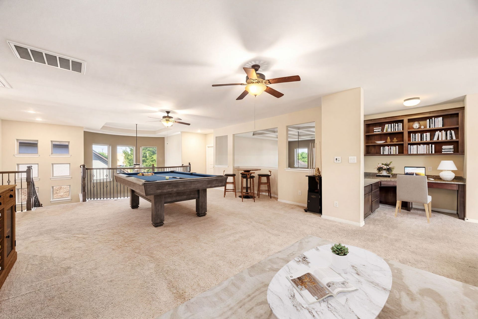 5102 Hawthorne Bend Drive, Katy, TX 77494 This oversized game room features a pool table, built-in bookshelves, a dedicated study nook, bar seating, and an iron-railed overlook, entertaining and productivity all in one! *Virtually Staged