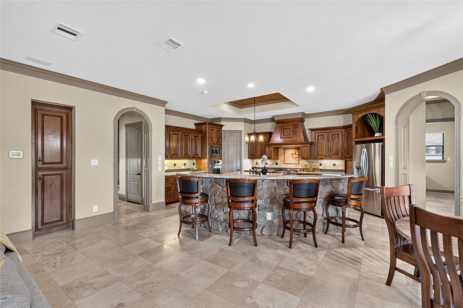This kitchen is a chef's dream with an oversized breakfast bar, commercial range, additional oven, separate vegetable sink and a plethora of cabinets and counter space