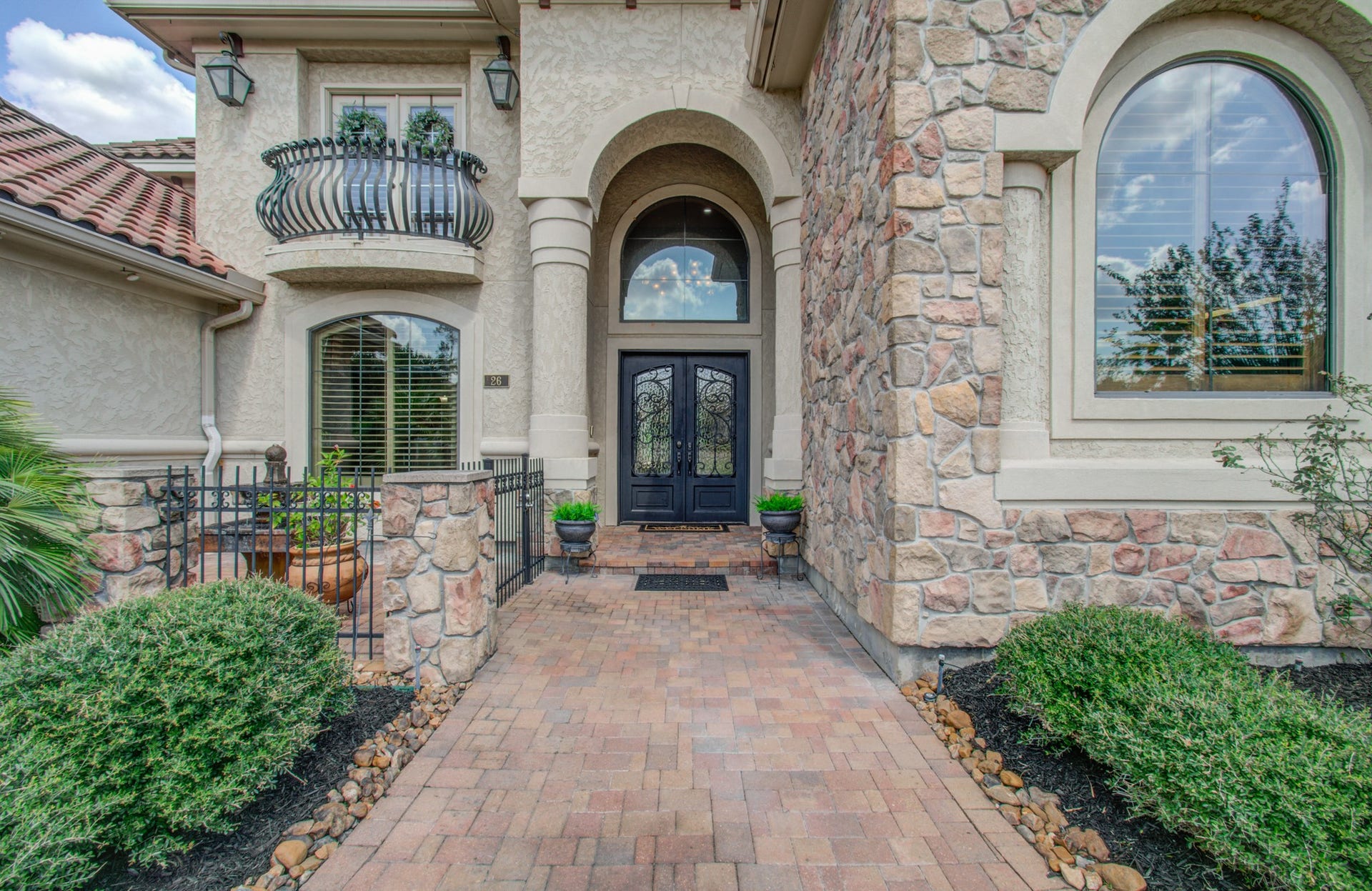The impressive front entry includes double metal doors and a fountain and courtyard.