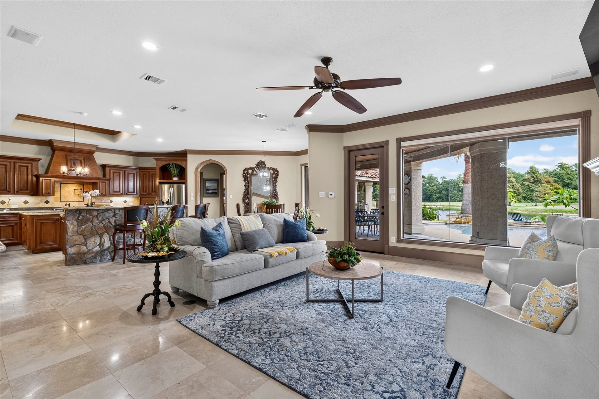 Livingroom open to the Kitchen and breakfast room with sweeping views of the backyard, pond and 3rd green of the 3rd green at Augusta Pines Golf Course