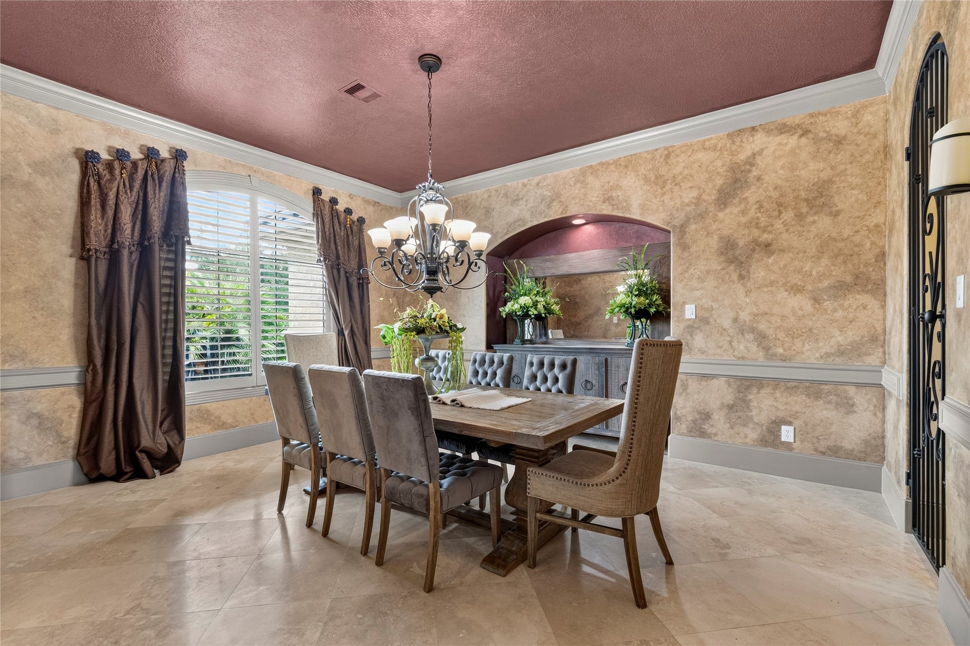 The oversized Formal Dining room includes an alcove perfect for your buffet and a decorative wrought iron door to the wet bar