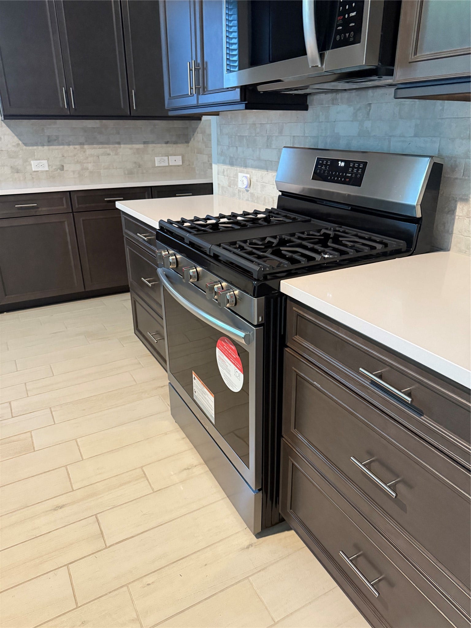 10526 William Park Drive, Missouri City, TX 77459 Modern kitchen featuring sleek dark cabinetry, stainless steel appliances, and elegant quartz countertops for a stylish and functional cooking space.
