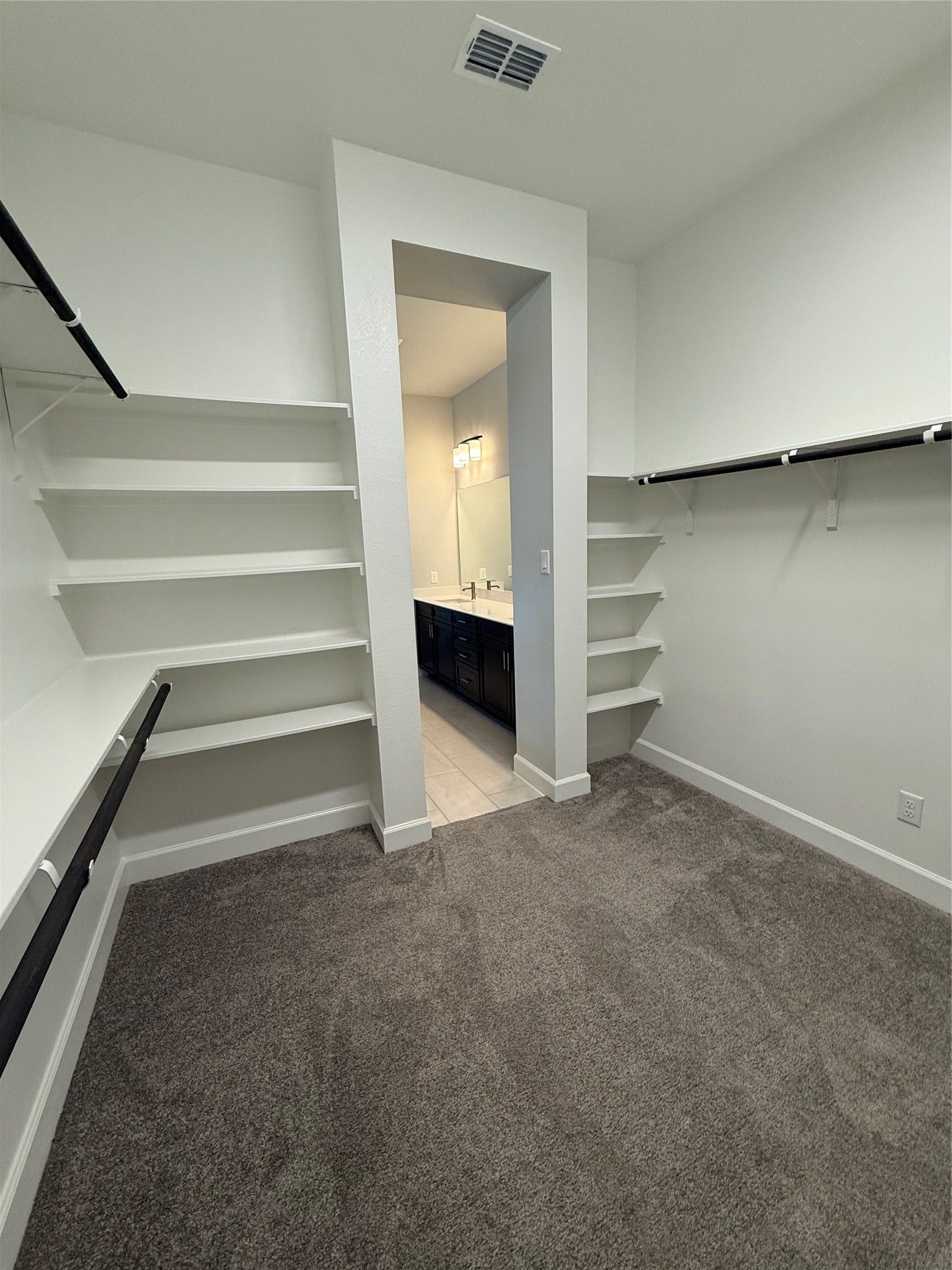 10526 William Park Drive, Missouri City, TX 77459 Spacious walk-in closet with ample shelving and hanging space, leading into a modern bathroom with a dual vanity.