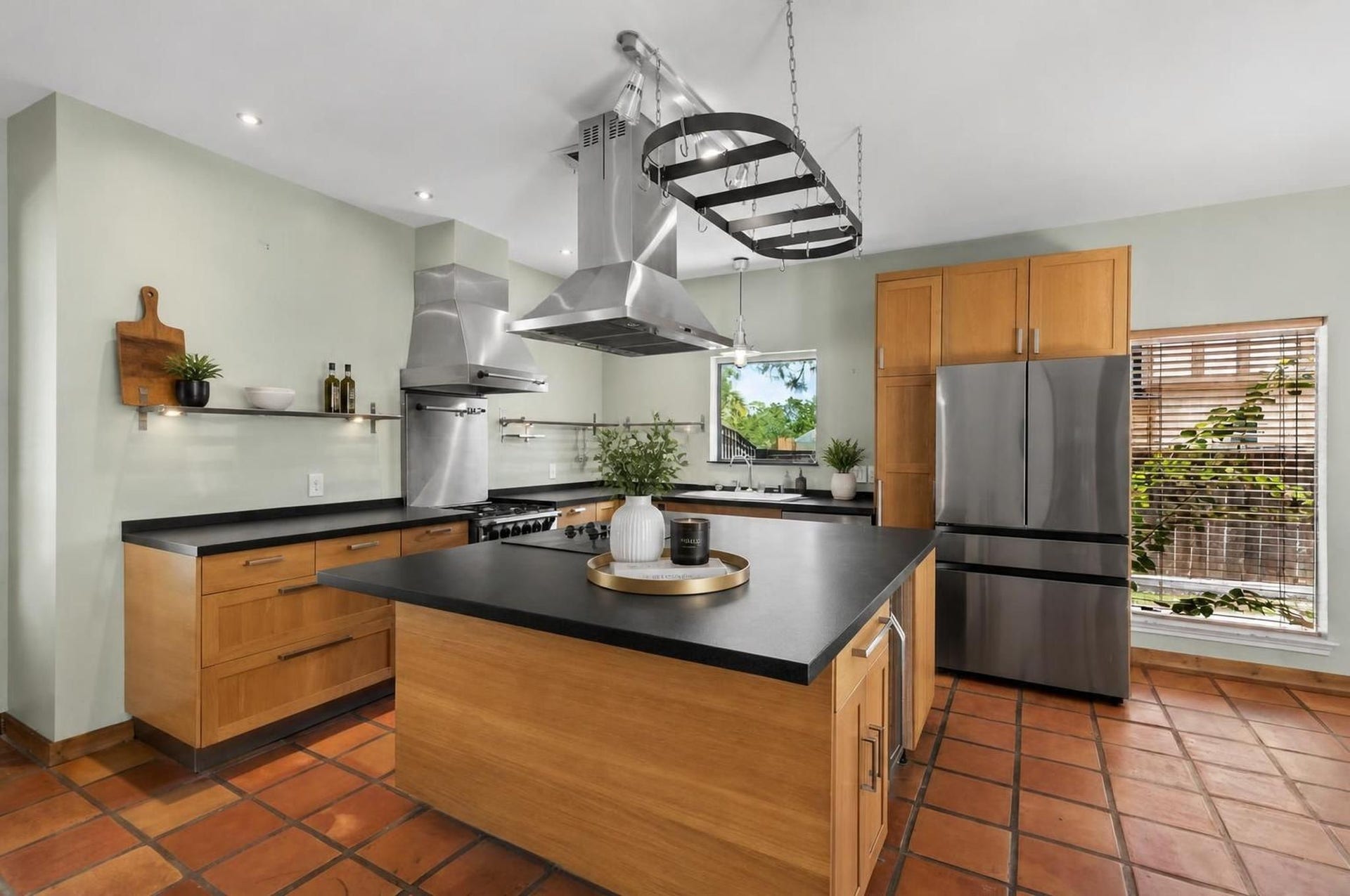11807 Carriage Hill Drive, Houston, TX 77077 The remodeled kitchen centers around a massive honed granite island with cooktop, breakfast bar seating, two ovens, pantry storage, and a wine/beverage fridge. The space is designed as one of the strongest features of the home.