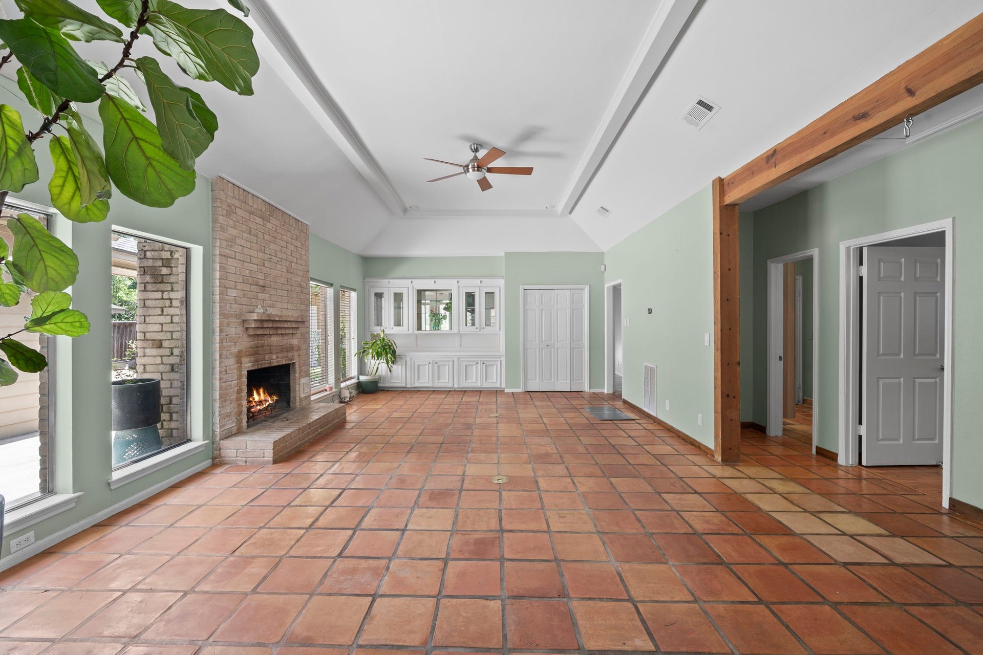 11807 Carriage Hill Drive, Houston, TX 77077 The unfurnished living room highlights the vaulted ceiling, fireplace placement, wood flooring, and generous proportions. The space is open, bright, and directly connected to the kitchen and dining areas.