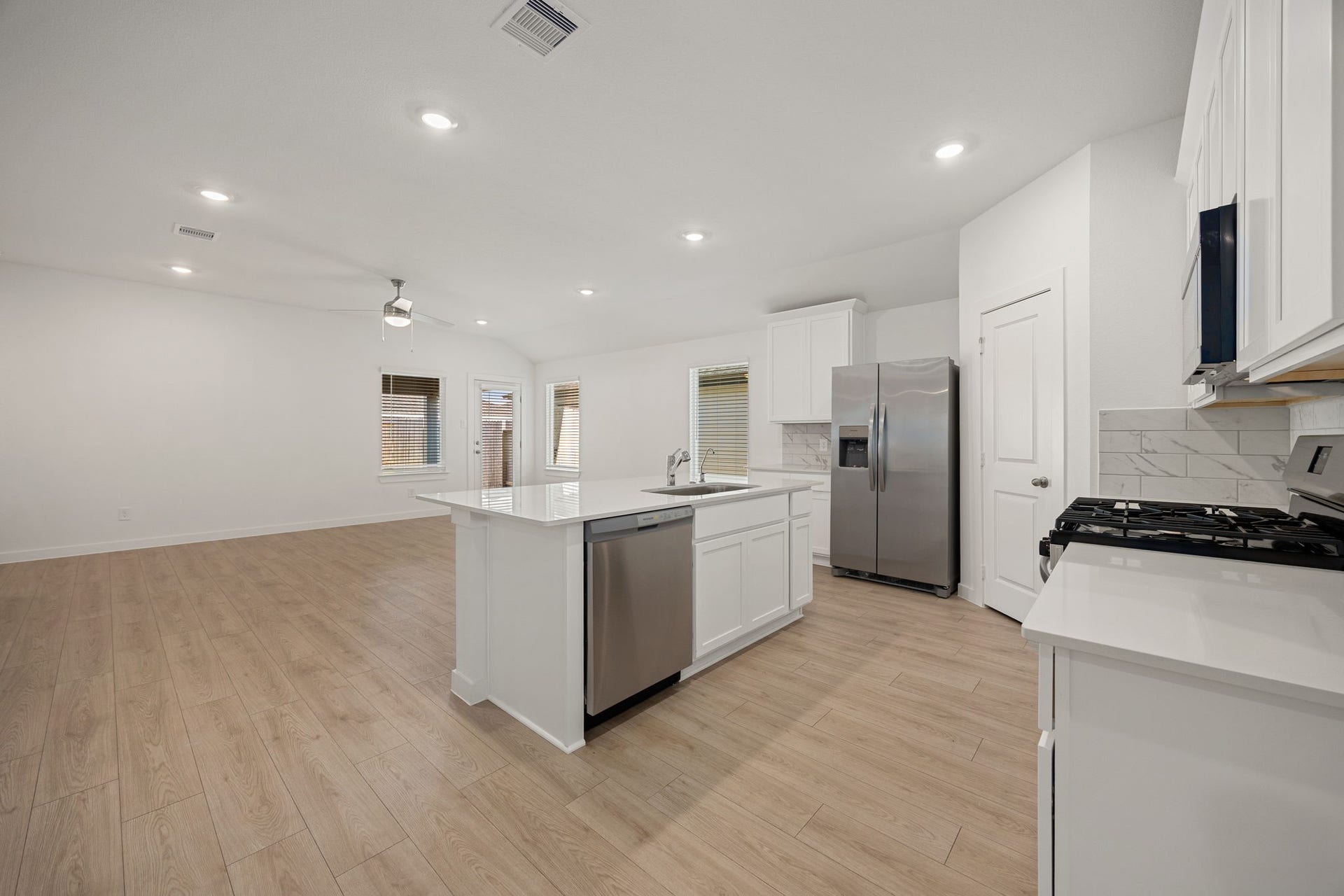Another angle highlights the stainless steel refrigerator, dishwasher, and ample cabinetry, rounding out this well-equipped kitchen.