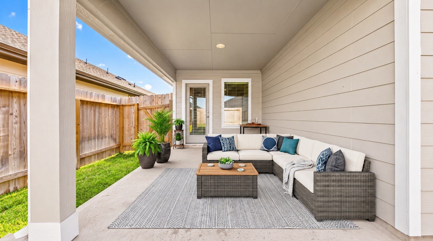 The covered back patio offers a shaded spot to relax, with direct access to the fenced backyard. Virtually staged.