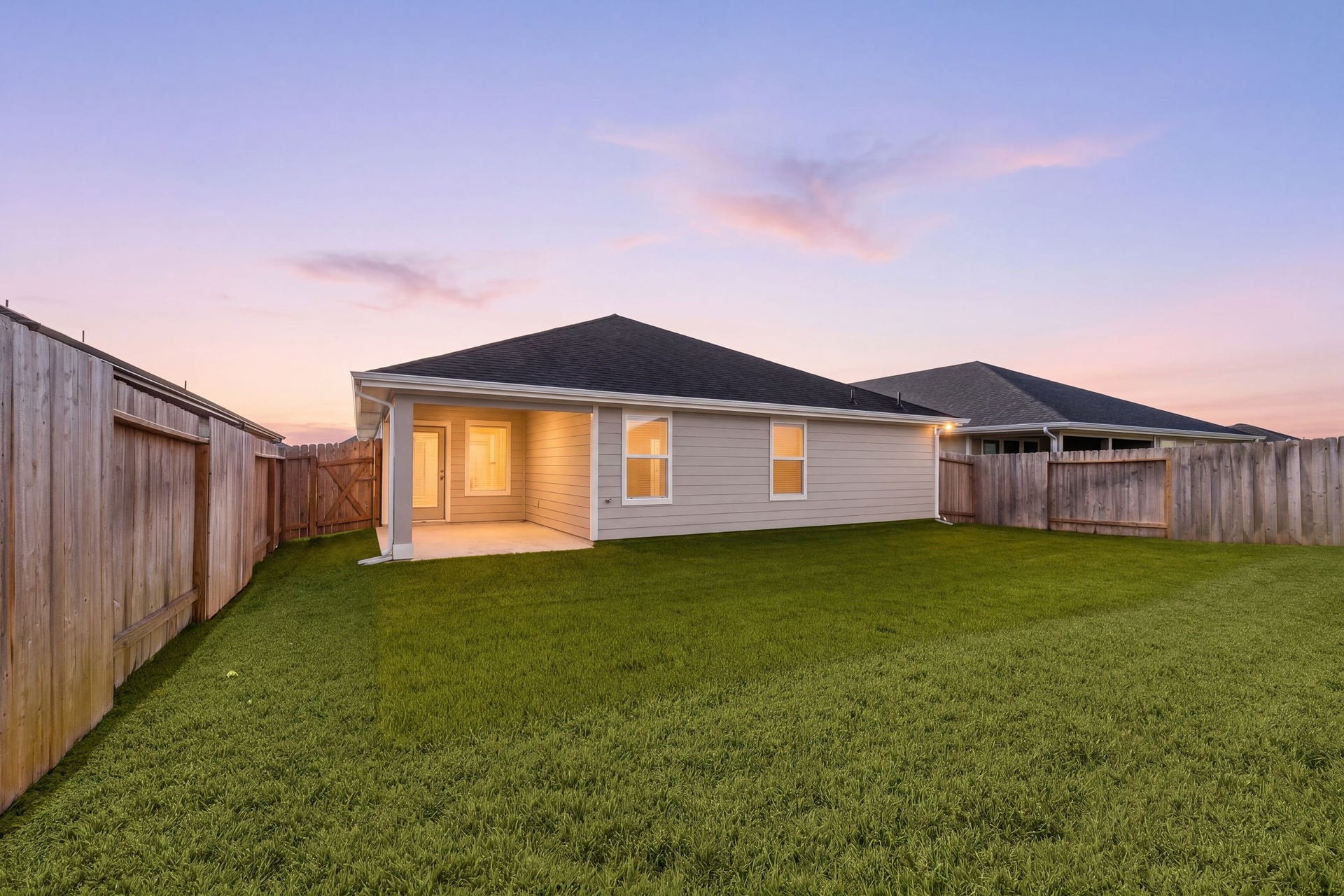 As the sun sets, this homes covered patio and spacious backyard create the perfect setting for evening relaxation.