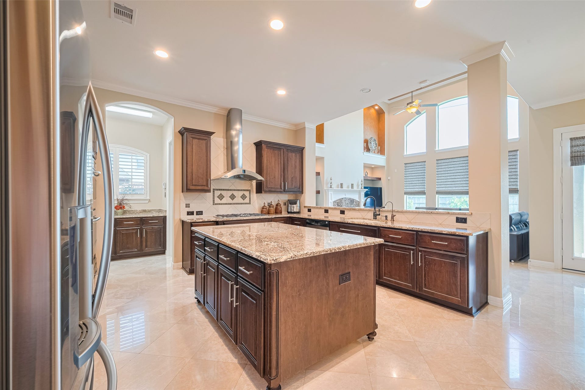 4722 Burclare Court, Sugar Land, TX 77479 Alternate kitchen angle emphasizing the oversized granite island, extensive storage, and open sightline into the two-story family room.