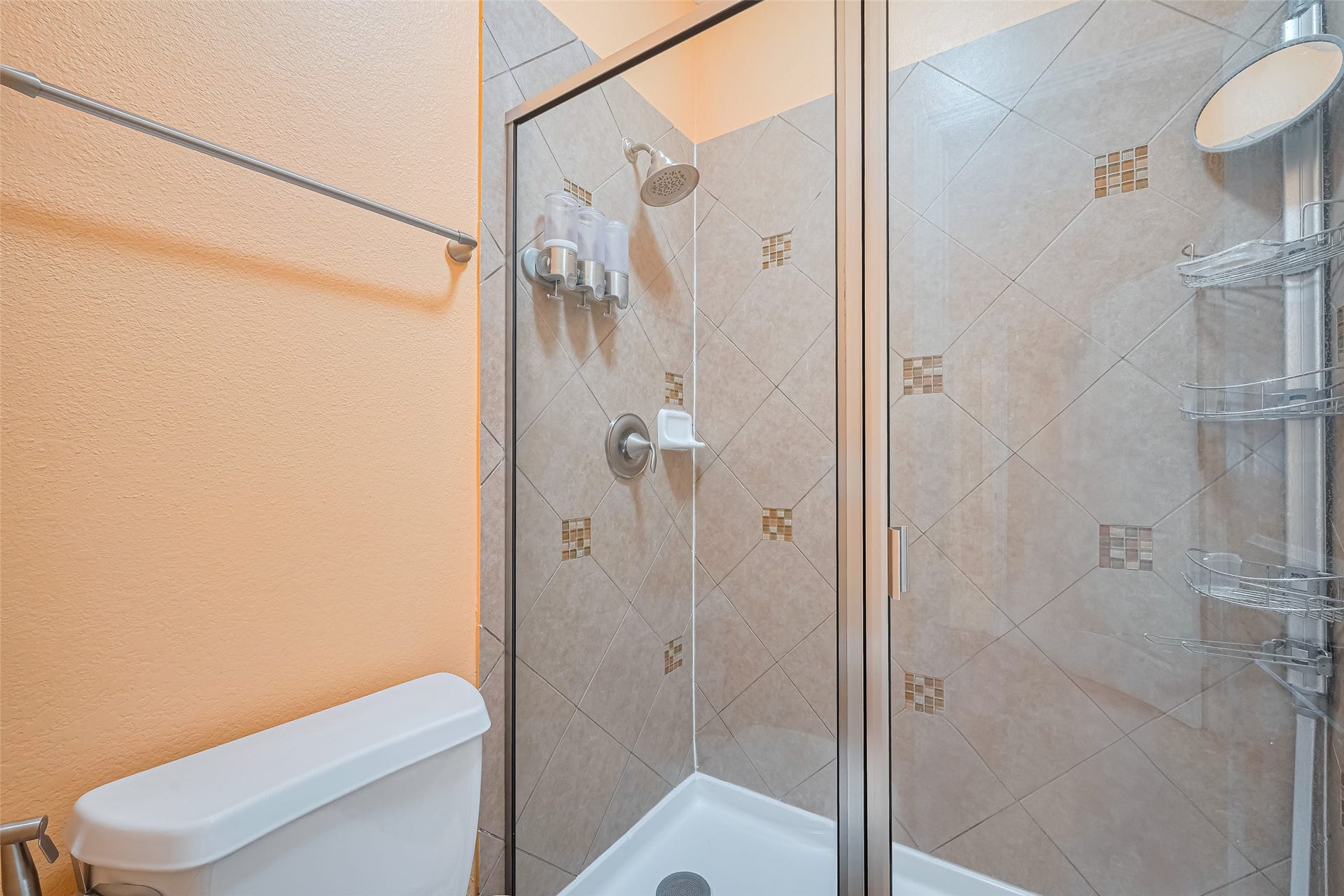 4722 Burclare Court, Sugar Land, TX 77479 Tiled fourth bathroom shower featuring decorative accent details and a sleek glass enclosure.