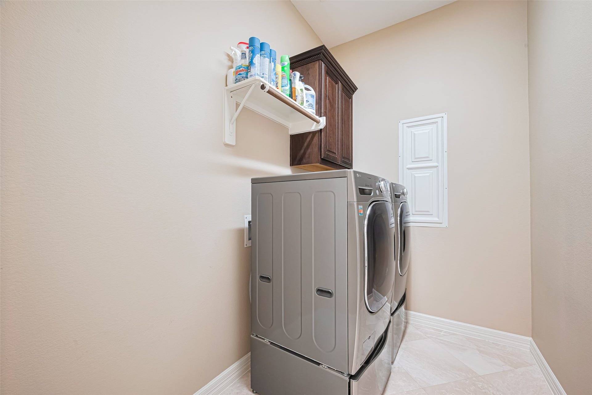 4722 Burclare Court, Sugar Land, TX 77479 Dedicated laundry room featuring side-by-side washer and dryer, built-in cabinetry, and convenient overhead storage.