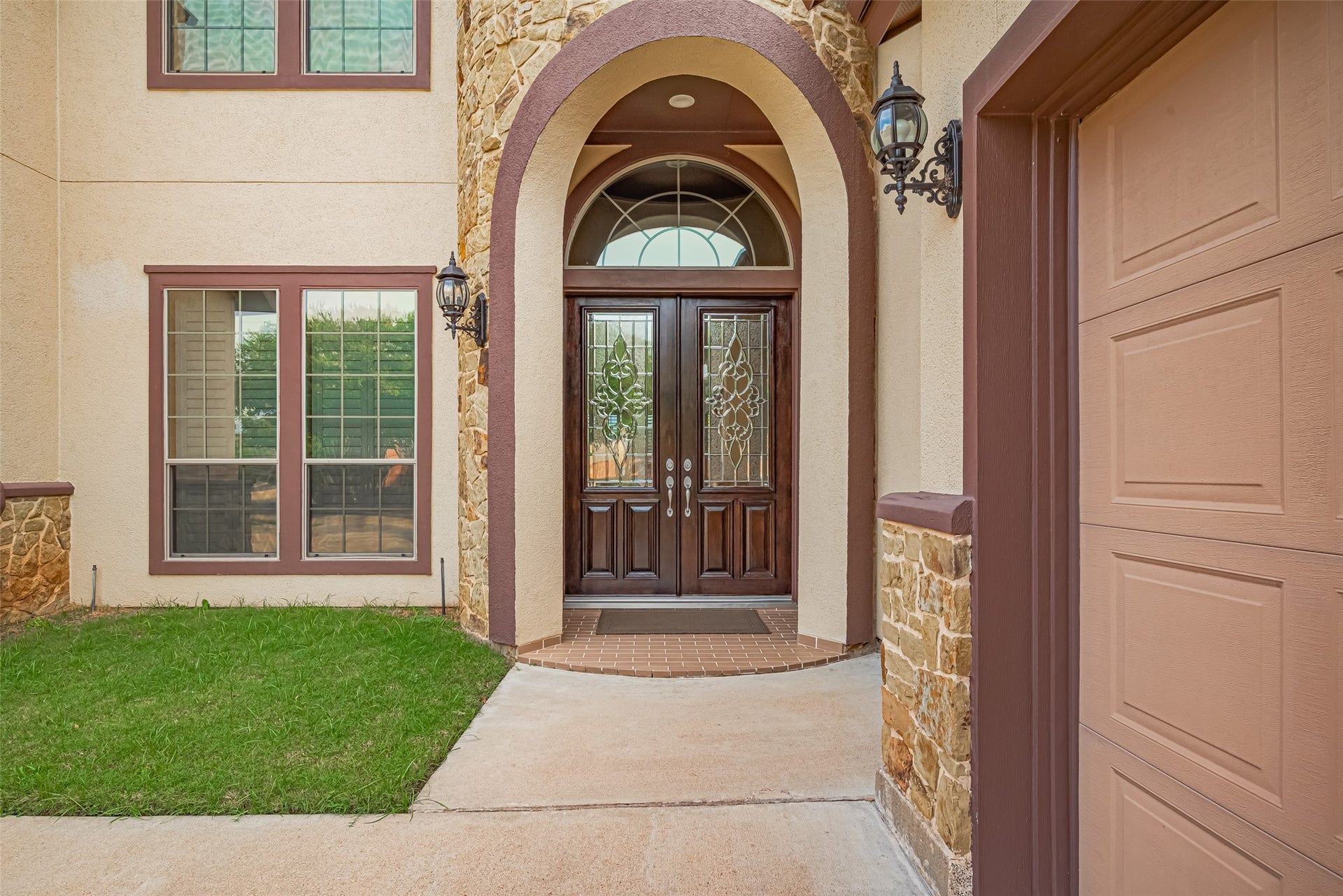 4722 Burclare Court, Sugar Land, TX 77479 Welcoming covered entrance framed by stonework, decorative double doors, and a graceful arched transom.