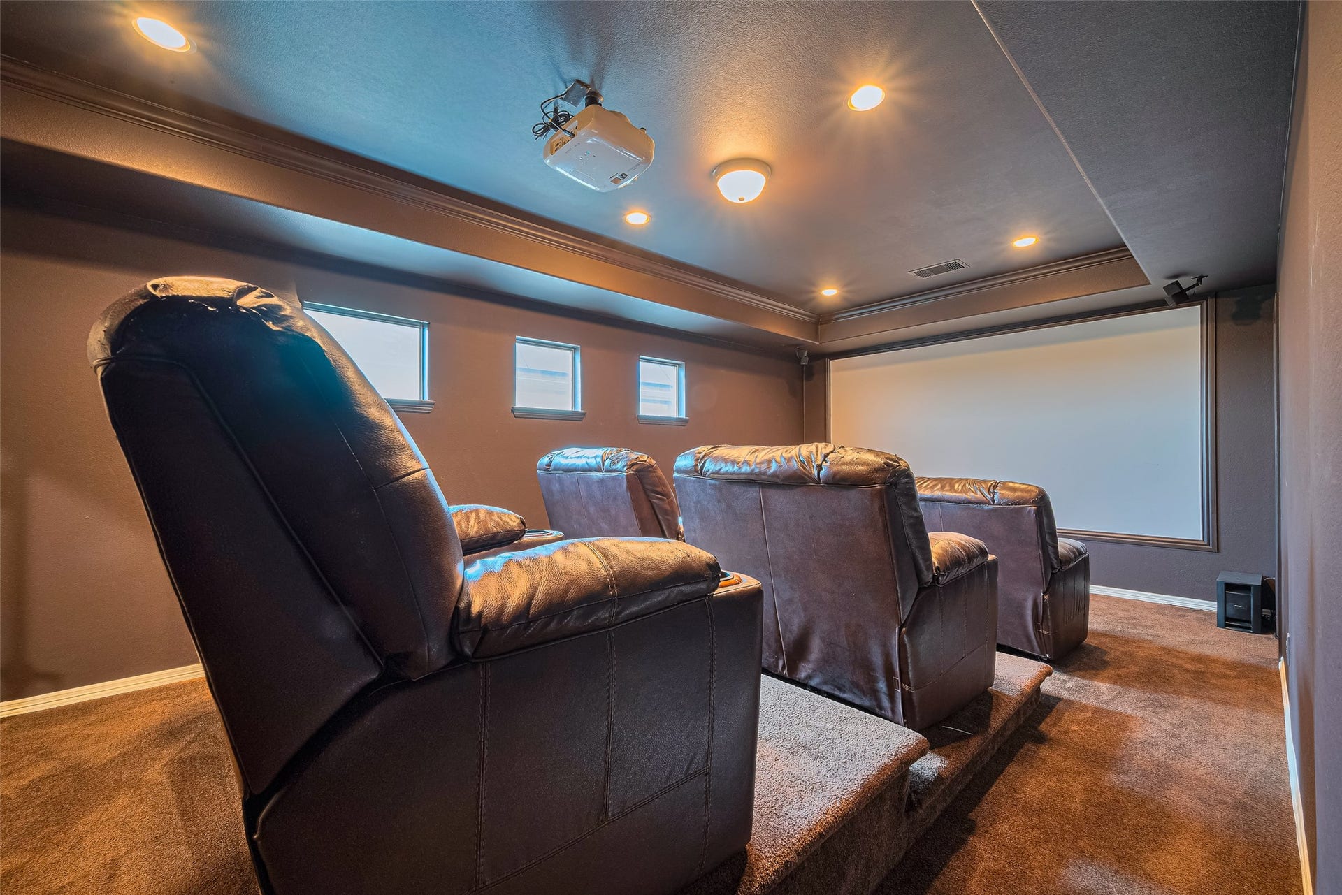 4722 Burclare Court, Sugar Land, TX 77479 Dedicated home theater featuring tiered leather seating, a large projection screen, ceiling-mounted projector, and immersive surround sound.