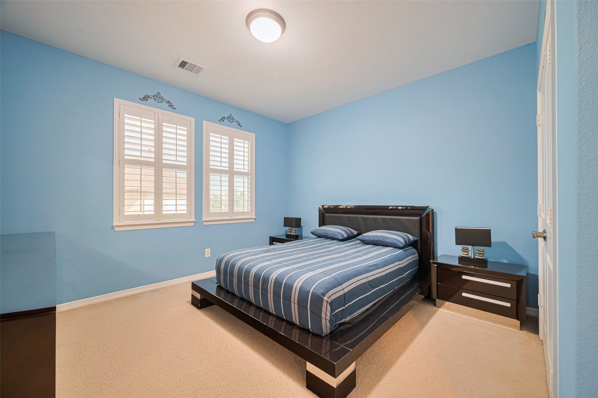 4722 Burclare Court, Sugar Land, TX 77479 Spacious secondary bedroom featuring calming blue tones, plush carpeting, generous natural light, and ample room for comfortable furnishings.