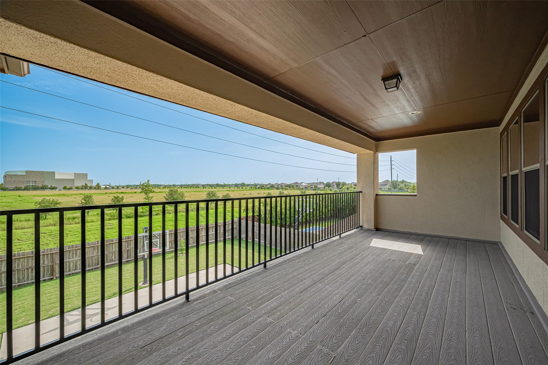 4722 Burclare Court, Sugar Land, TX 77479 Another view of the expansive covered balcony, showcasing generous outdoor living space and peaceful open green views.