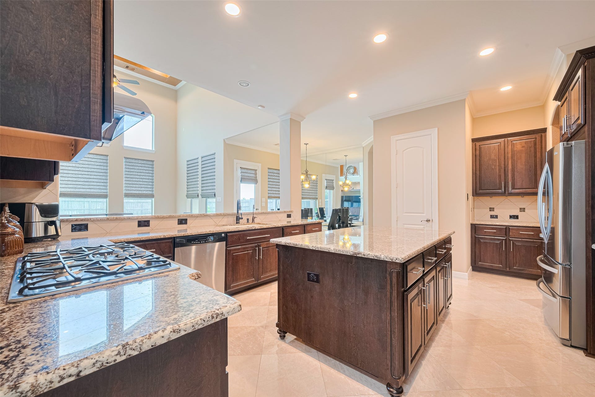 4722 Burclare Court, Sugar Land, TX 77479 Wide kitchen view presenting the central island, generous workspace, rich wood finishes, and effortless flow into the adjoining living spaces.
