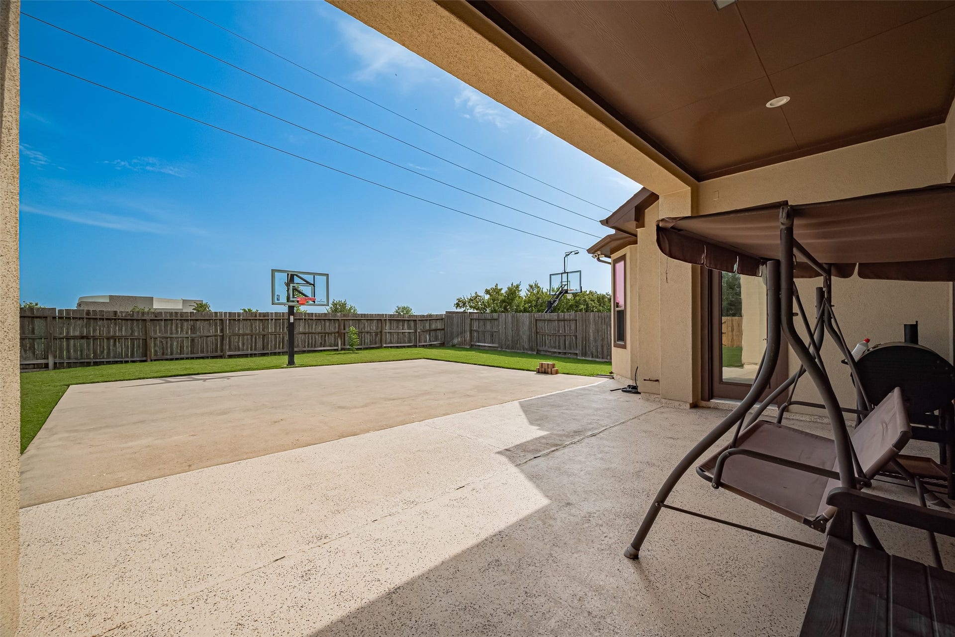 4722 Burclare Court, Sugar Land, TX 77479 Spacious covered patio overlooking a large fenced backyard with an expansive concrete play area and basketball hoopsideal for outdoor recreation and entertaining.