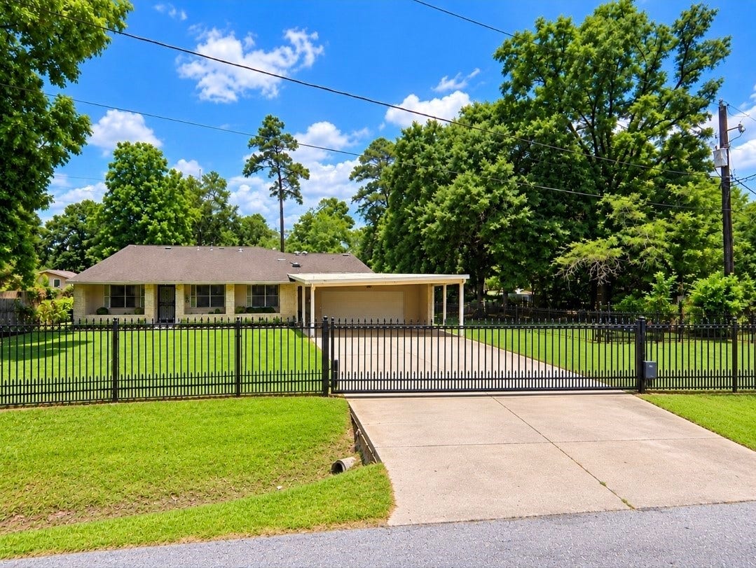 7929 Talton Street, Houston, TX 77028 Charming single-story home with a spacious front yard, secure gated driveway, and ample carport, nestled among mature trees for added privacy and tranquility.