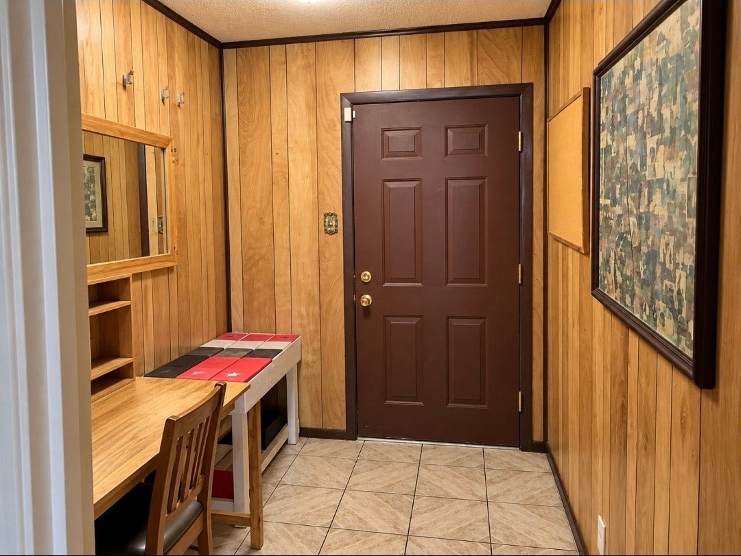 7929 Talton Street, Houston, TX 77028 Cozy entryway featuring warm wood paneling, a functional desk area, and a decorative tiled floor, offering a welcoming first impression.