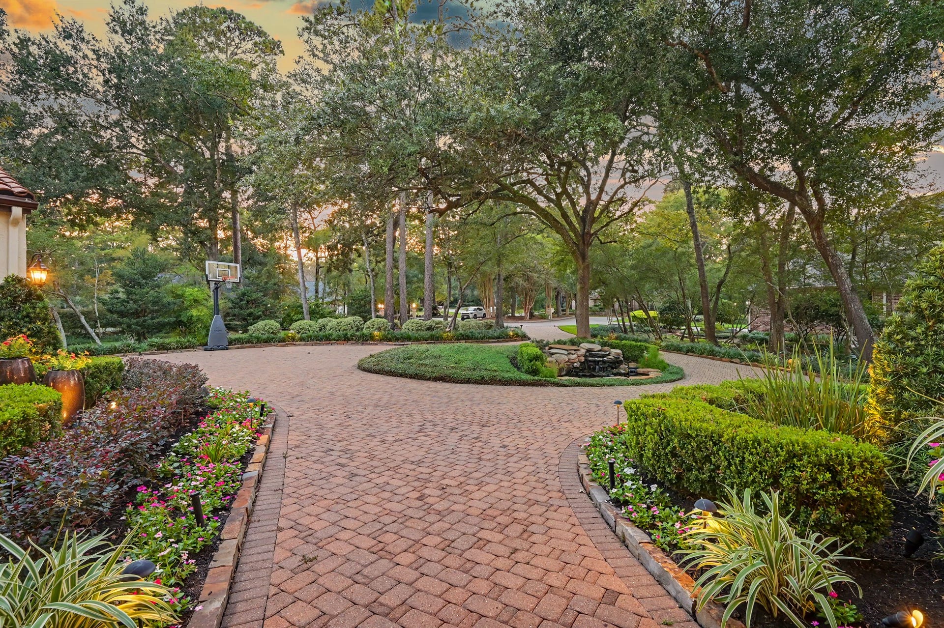 Expansive circular driveway centered around a tranquil koi pond, offering an elegant and welcoming arrival.