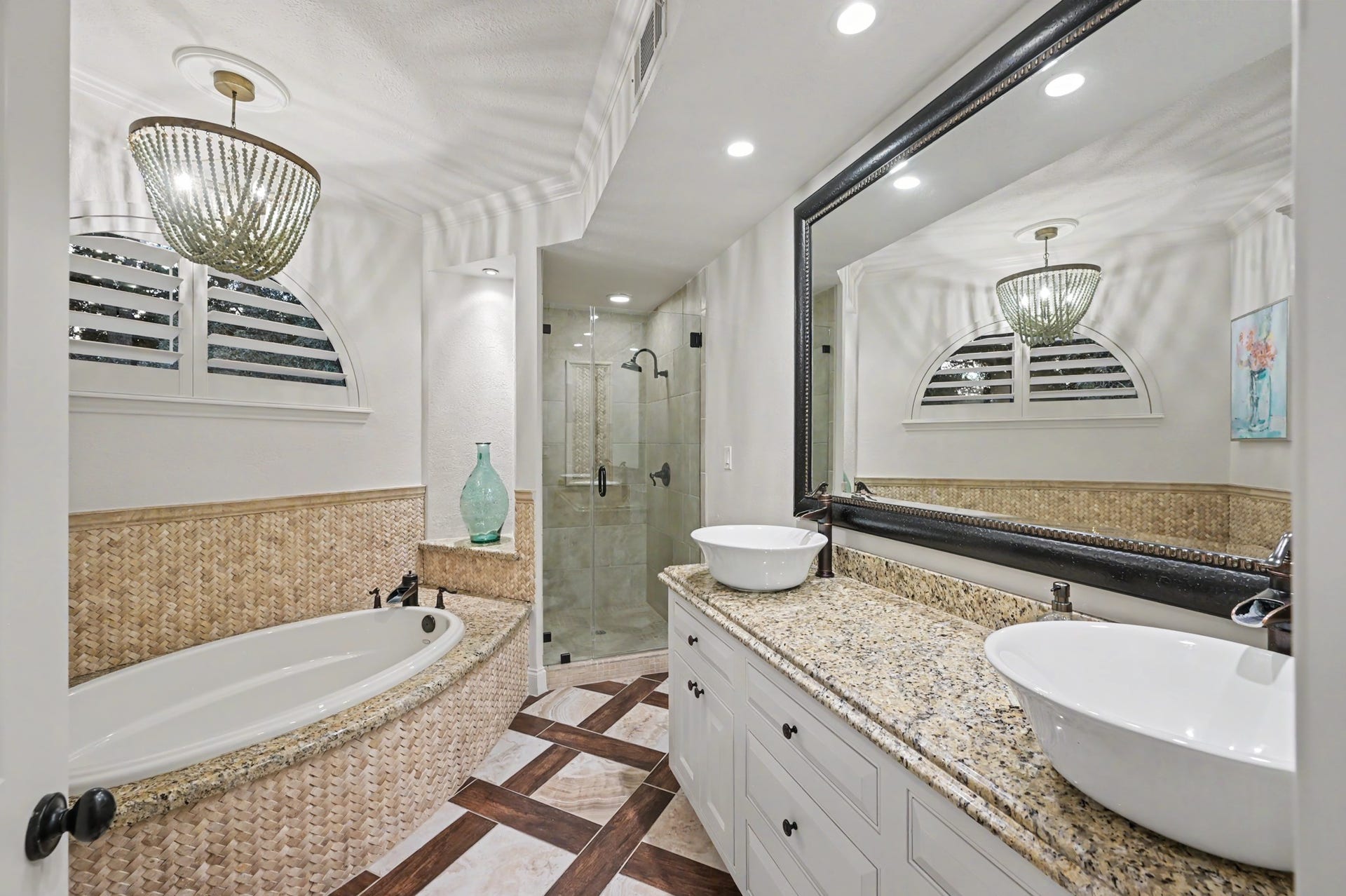 Luxurious guest en suite featuring dual sinks, a well appointed tub and stand up shower