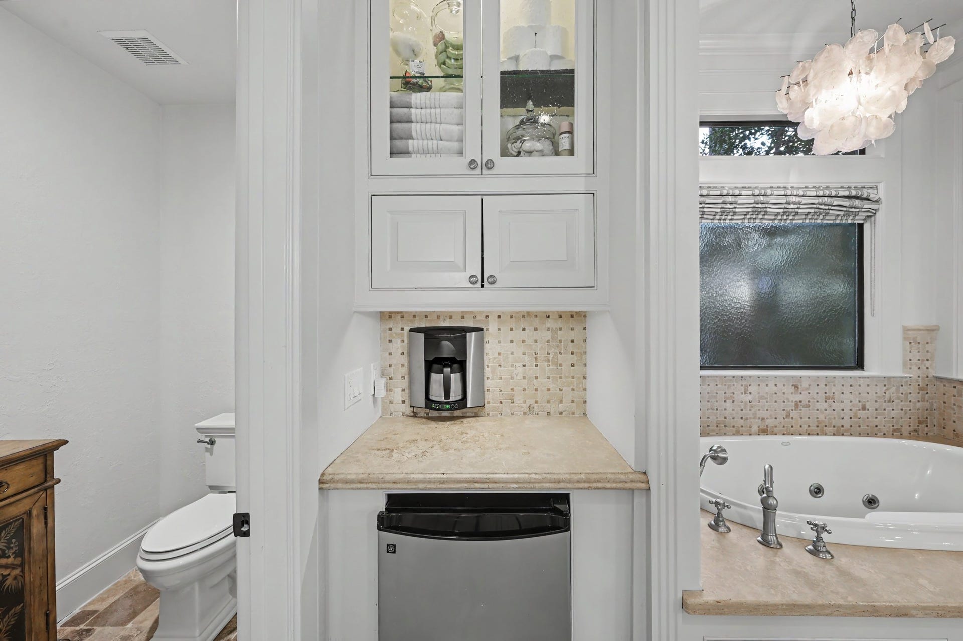 Convenient built-in coffee station featuring custom cabinetry, countertop workspace, and a beverage refrigerator