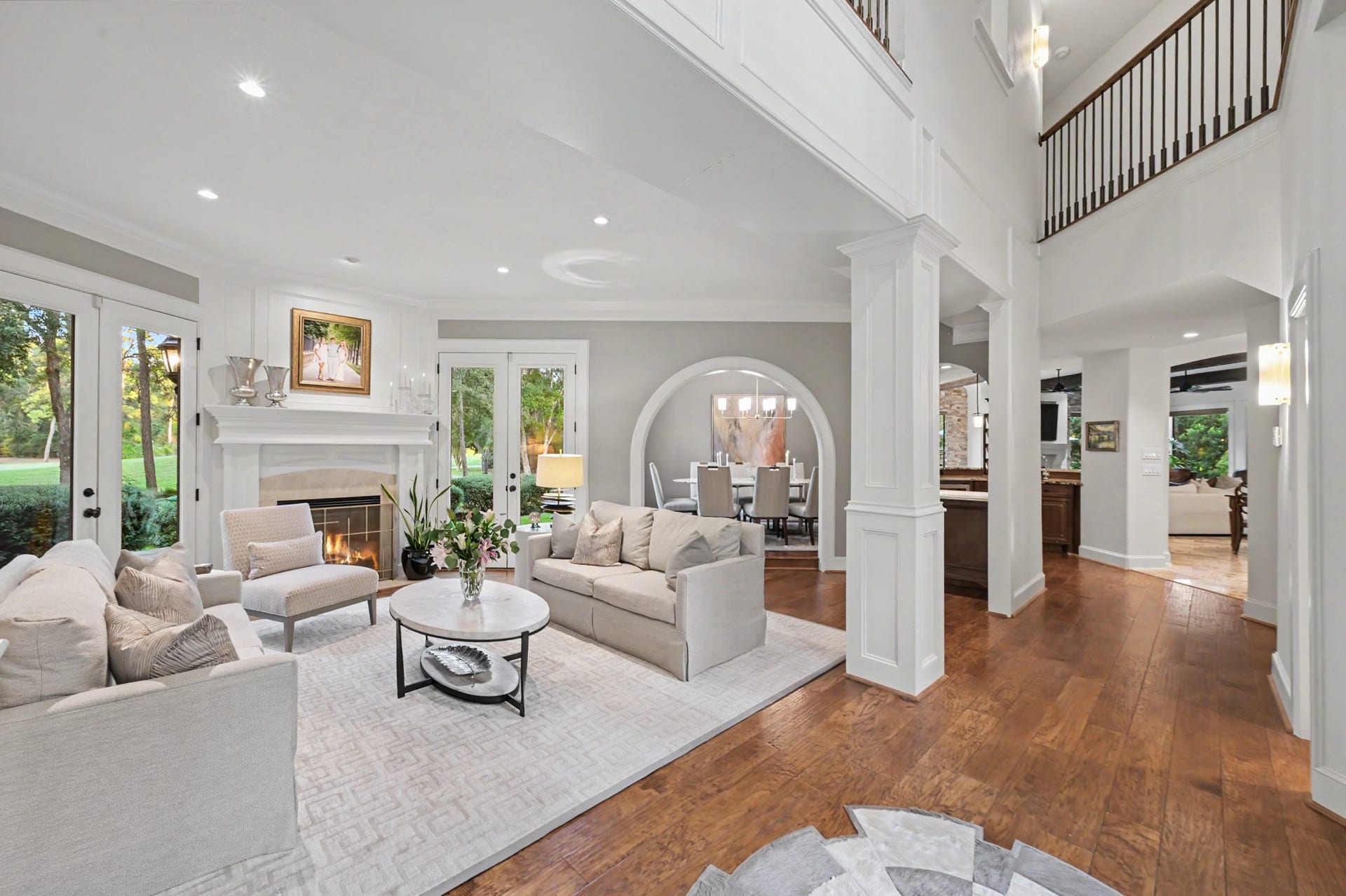 Elegant formal living room highlighted by soaring ceilings and an open flow into the formal dining area.