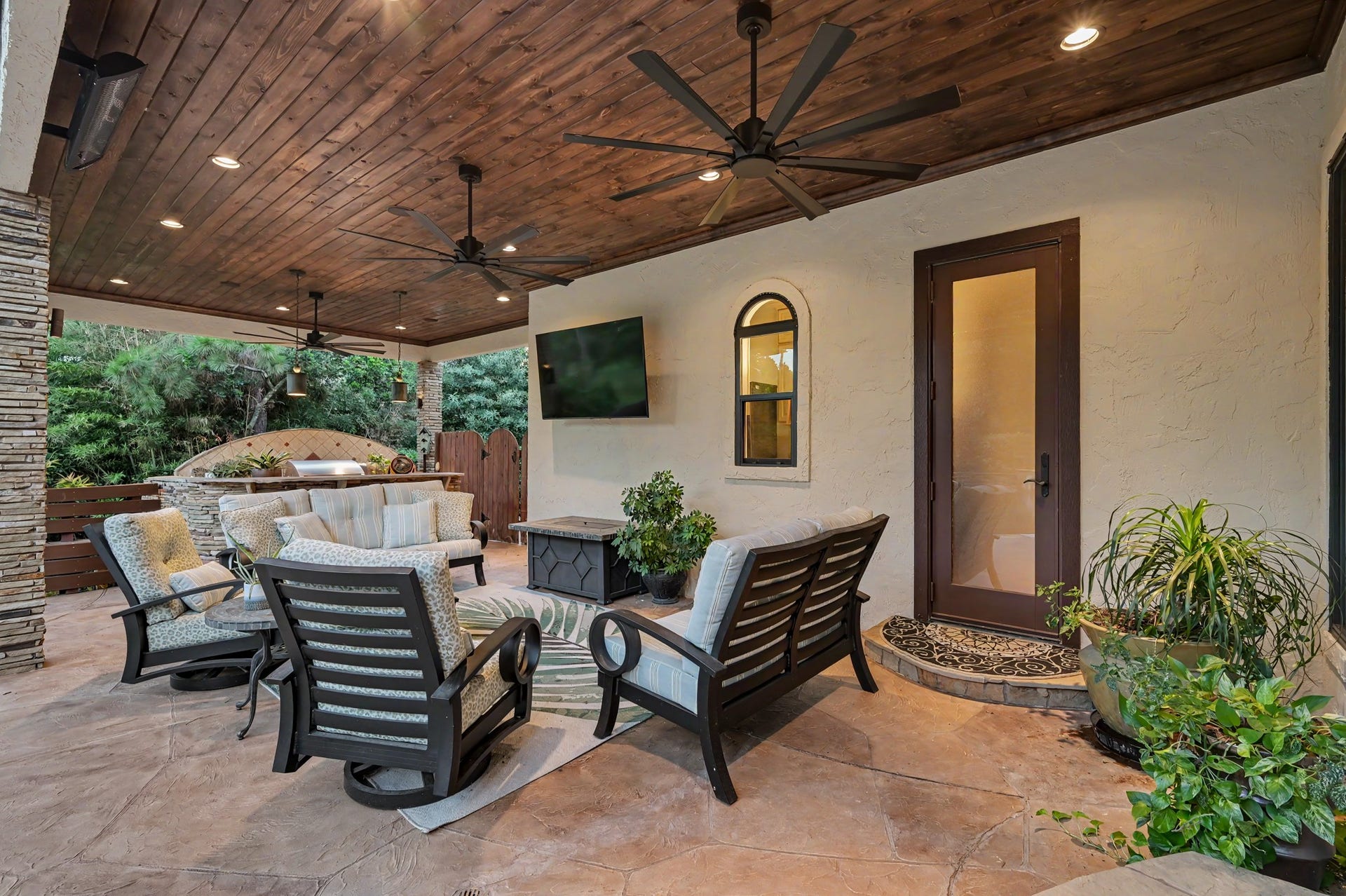 Expansive covered outdoor living area featuring: multiple ceiling fans, outdoor heat radiators and generous space for relaxing and entertaining year-round.